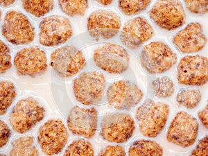 Top view of corn flakes floating in milk close up.