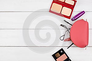 Top view of cosmetic items on white wood background
