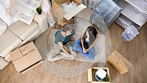 Top view of couple moving in using tablet