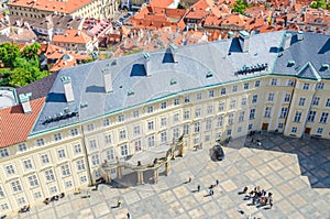 Top view of courtyard square of Prague Castle and Old Royal Palace with small figures of walking people