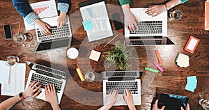 Top view of coworking people sitting together around table. Business meeting of young creative hipsters. Team of analysts make con