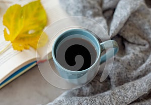 Top view of cozy blanket, open book and hot cup of coffee on a cold day. Relaxation and hygge concept. Top view with copy