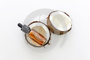 Top view of cracked Coconuts with Coconut essential oil in eyedropper 