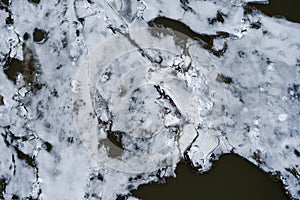 Top view of cracked ice in the river. Aerial photo