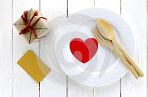 Top view of craft box on dish and spoon fork on white wood background