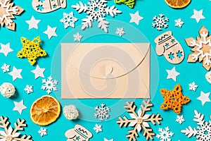 Top view of craft envelope on blue background with New Year toys and decorations. Christmas time concept