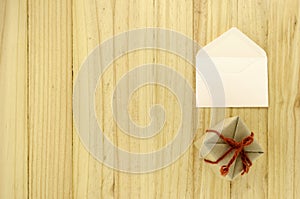 Top view of craft gift box with envelope on wood