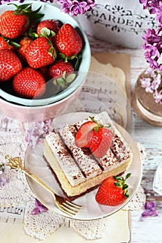 Top view of cream cake with strawberries and fresh fruits in the bowl