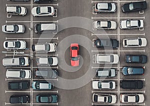 Top view of the crowded Parking lot with quadcopter or drone. Original bright automobile among the grey of mediocre cars. Parking photo