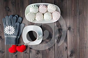 Top view of Cup of black coffee with gloves on wooden backgroun