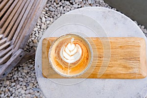 Top view of cup of cappuccino with beautiful latte art on concrete table.