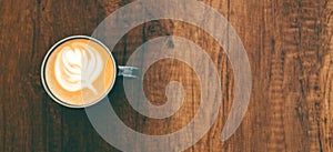 Top view cup of cappuccino on wooden table with beautiful latte art. Copy space