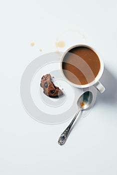 top view of cup of coffee with bitten chocolate chip cookie and spoon