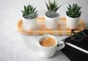 Top view cup of coffee with notebook, pencil and the glasseson wooden table background, modern lifstye concept