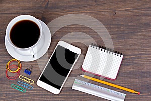 Top view of Cup of coffee with smart phone on wooden background