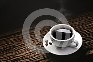 Top view of a cup of coffee with smoke and coffee beans on old wooden background