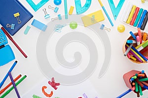 Top view of cup with colorful felt-tip pens and school supplies isolated on white.