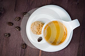 Top of view of cup of espresso coffee and biscuit near coffee beans