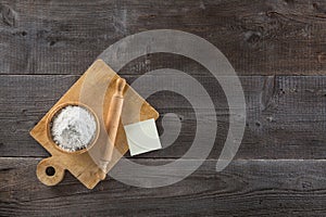 Top view of cup of flour and cutting board