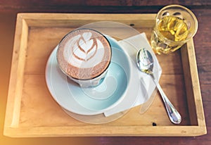 Top view cup of hot cocoa art on saucer with spoon and tea.