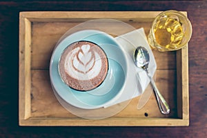 Top view cup of hot cocoa art on saucer with spoon and tea.