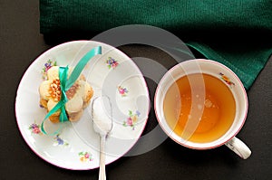Top view of a cup of tea with a teaspoon of sugar and biscuits