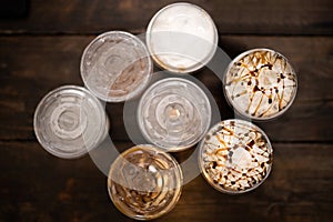 Top view of cups with cold drinks on wood  background-concept of sweets