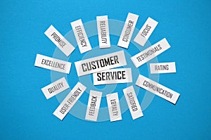 Top view of CUSTOMER SERVICE paper tag cloud on blue background