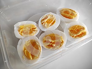 Top view of cut in half boiled eggs in white background