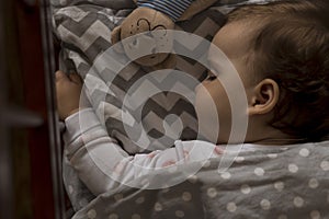 top view Cute little chubby baby girl kid sleeping sweetly in grey crib during lunch rest time in white and pink pajamas