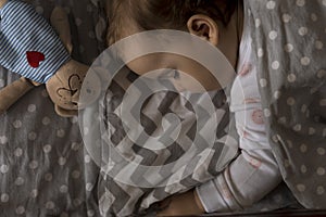 top view Cute little chubby baby girl kid sleeping sweetly in grey crib during lunch rest time in white and pink pajamas