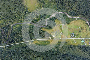 Top view of dark mountain hills covered with bare patches of cut down forest pine trees as result of deforestation