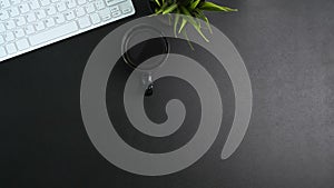 Top view of office desk with coffee cup, house plant, keyboard and copy space.