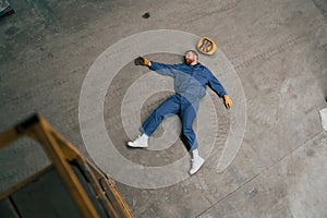 Top view of dead factory worker that lying on the ground