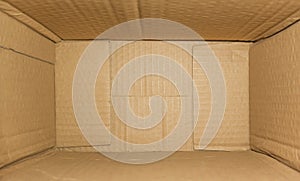 Top view of deep empty cardboard box, opened brown paper carton box, empty cardboard box close up, inside view