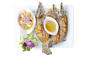 Top view of Deep fried Sea bass with Fish Sauce in white plate isolated on white background.