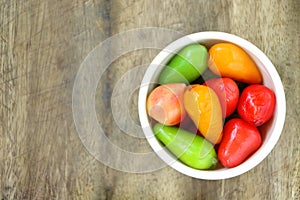 Top view of DELETABLE IMITATION FRUITS KANOM LOOK CHOUP in white small bowl on wood table