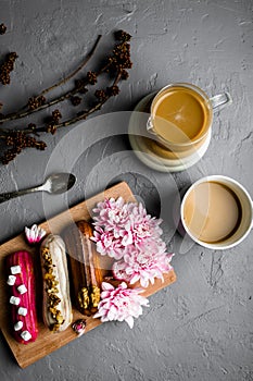 Top view of delicious breakfast on with coffee and sweets on gray textured background.