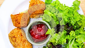Top view of delicious Cylindrical Croquettes and fresh vegetables in a white plate