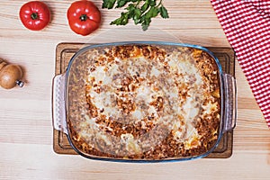 Top view of a delicious traditional italian lasagna made with minced beef bolognese sauce on wooden table