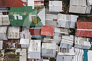 Top view of densely packed rickety houses with flimsy sheet metal roofing. At an impoverished area in the town of Ubay, Bohol