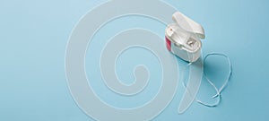 Top view of dental floss in white box on blue background