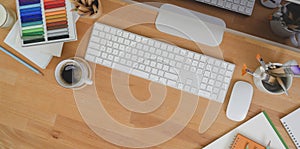 Top view of designer workplace with desktop computer and office supplies on wooden table