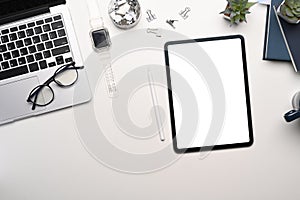 Top view of designer workspace with digital tablet, laptop and equipment white table.