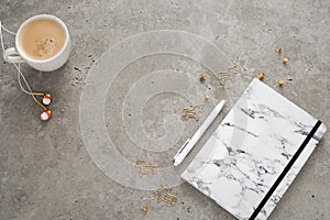 Top view of desk with notepad, coffee cup, earphones, pen and staples. Flat lay, free space for text, copy space. Desk