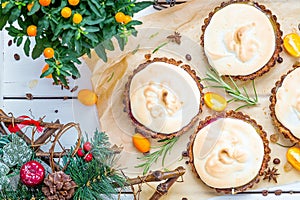 Top View of Dessert Tartlets with Berries, Meringue and Kumquat Jam on White Wooden Background