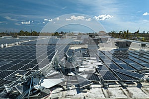 Top view of destroyed by hurricane Ian photovoltaic solar panels mounted on industrial building roof for producing green