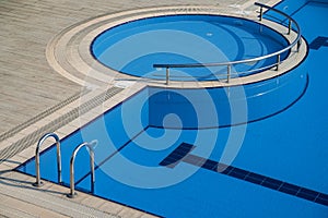 Top view detail of pool with blue water and entrance with chrome grab bars