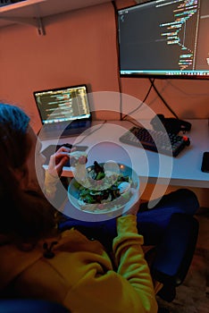 Top view of IT developer eat salad while program