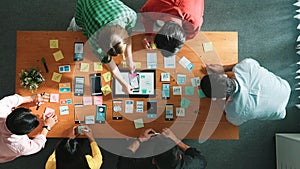 Top view of developer team working together to write idea on note. Convocation.